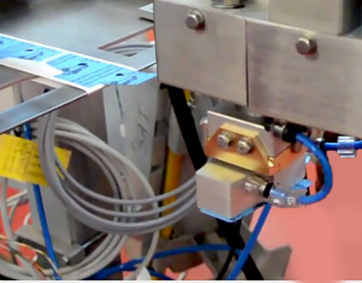dettaglio del tampone che preleva un'etichetta per pastiglie freno auto ruotandola di 90°
